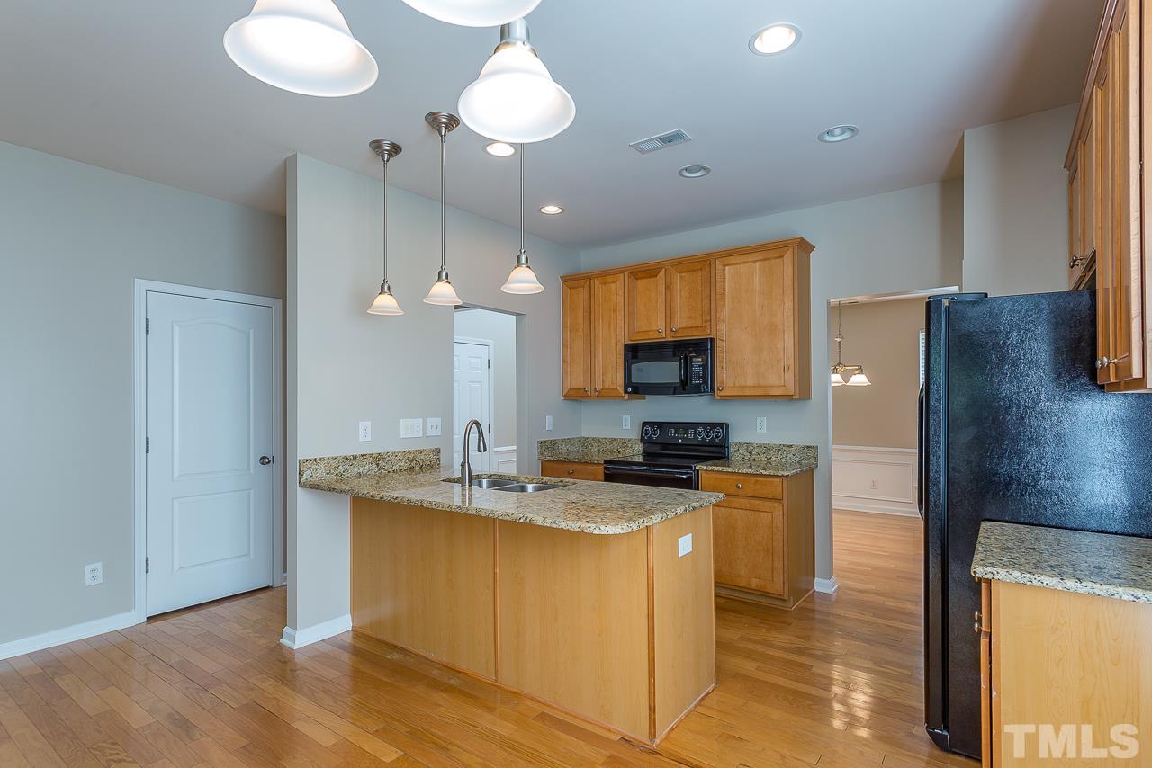 3601 Cathedral Bell Road Raleigh, NC 27614 - Photo 9 of 25 a kitchen with kitchen island granite countertop a sink a counter top space appliances and cabinets