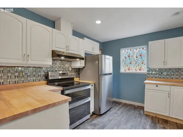 a kitchen with sink a stove and cabinets