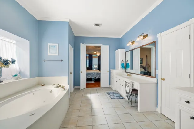 a spacious en suite bathroom with a tub and a sink