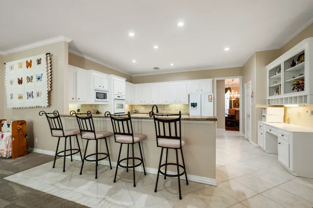 a dining hall with stainless steel appliances a dining table and chairs