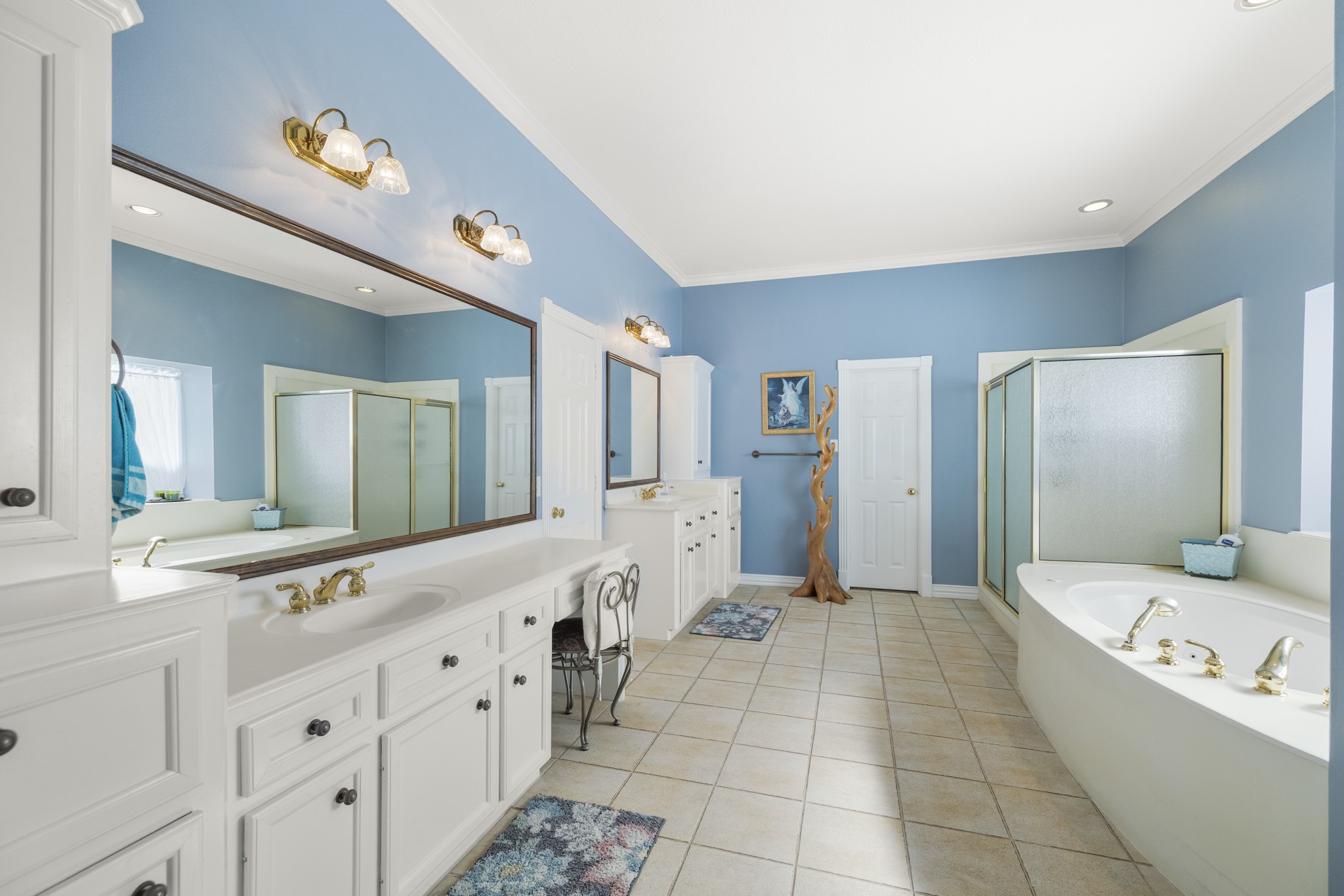 19315 Puget Lane Spring, TX 77388 - Photo 10 of 49 a bathroom with a bathtub a double vanity sink a mirror and a bathtub