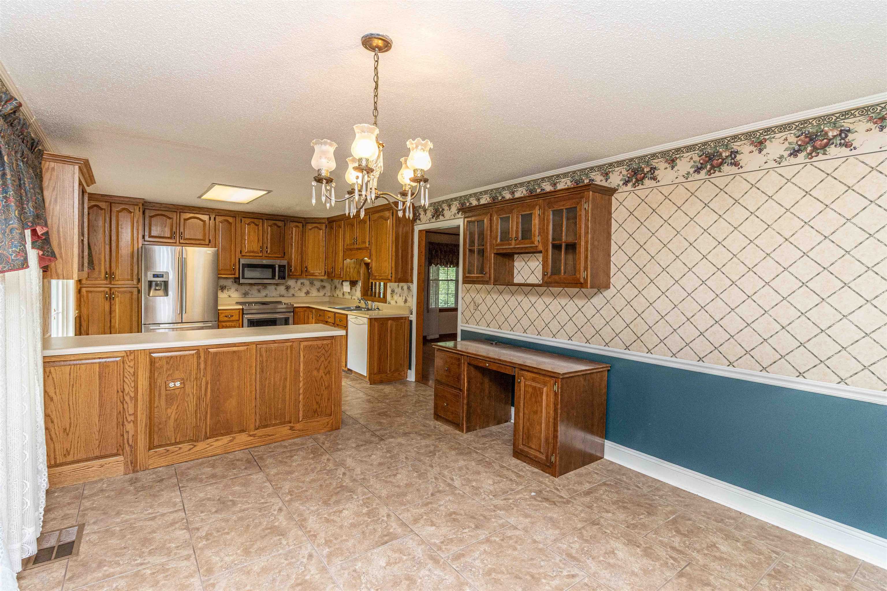 239 Old Road South, Unit 5 Selmer, TN 38375 - Photo 13 of 34 a kitchen with stainless steel appliances kitchen island granite countertop a refrigerator in it