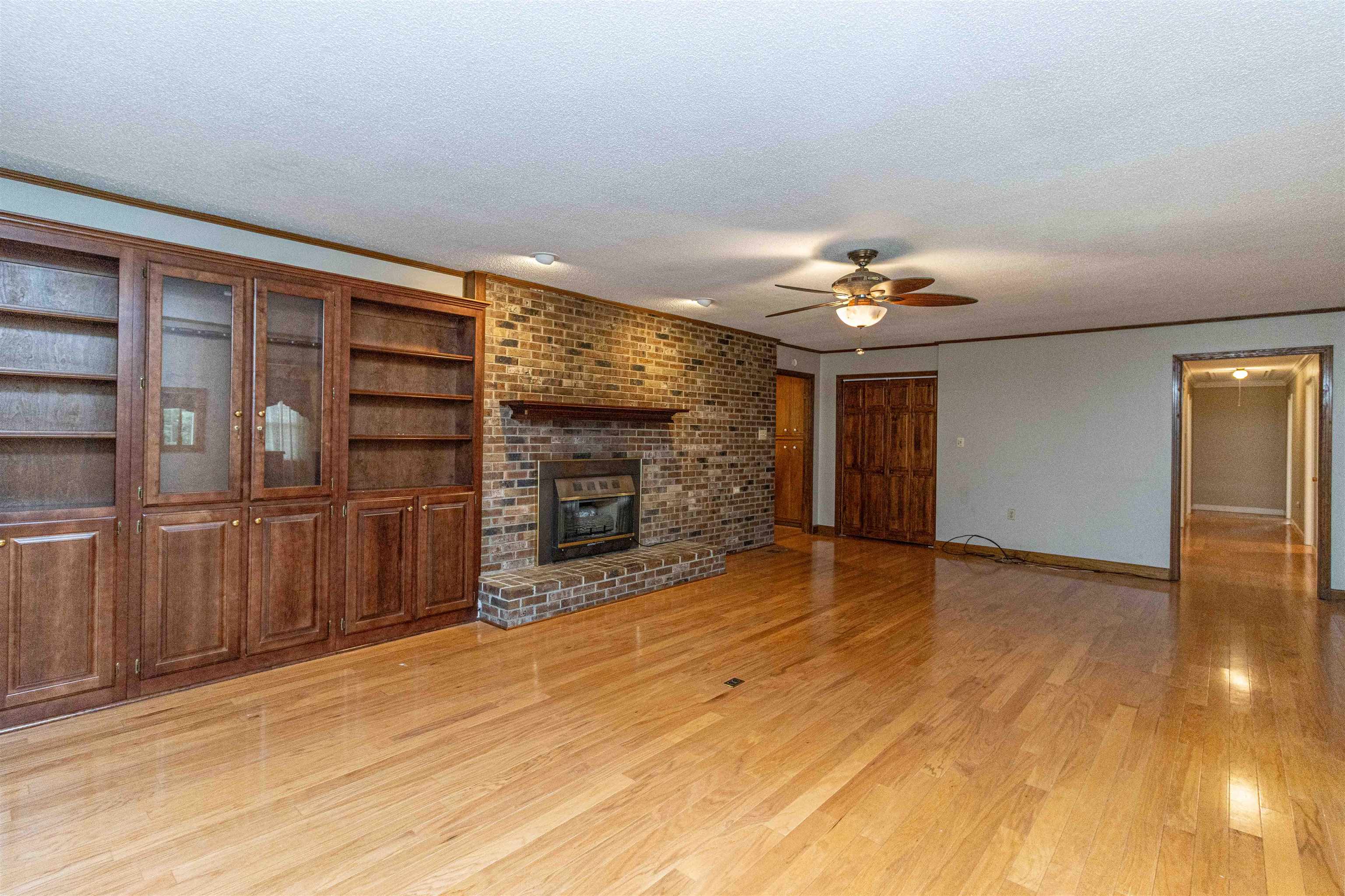239 Old Road South, Unit 5 Selmer, TN 38375 - Photo 6 of 34 a view of an empty room with a fireplace and chandelier fan