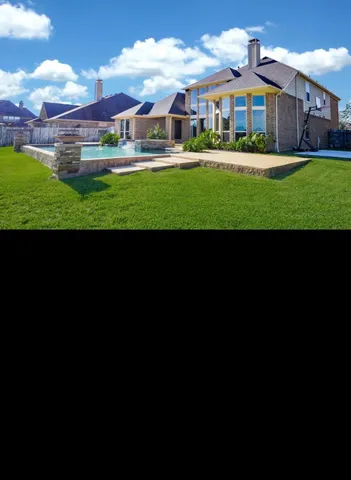 a view of house in front of a big yard with potted plants