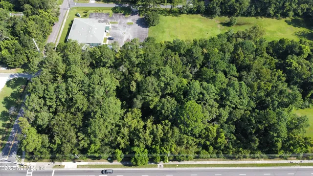 an aerial view of residential house with outdoor space and trees around