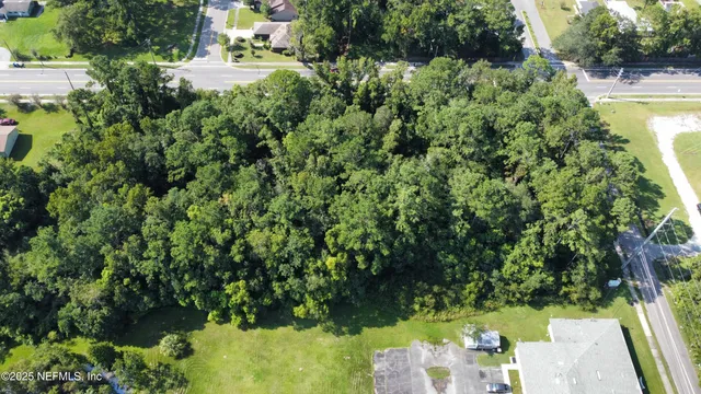 an aerial view of residential house with outdoor space and trees all around