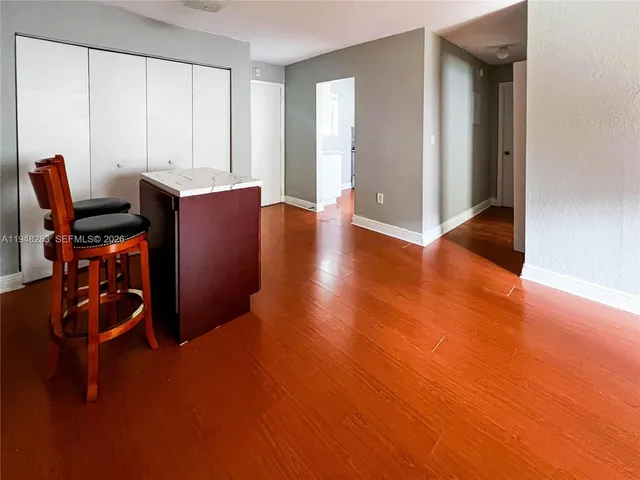 a kitchen with granite countertop white cabinets and black appliances