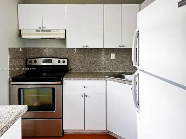 a kitchen with granite countertop cabinets stainless steel appliances and a counter space