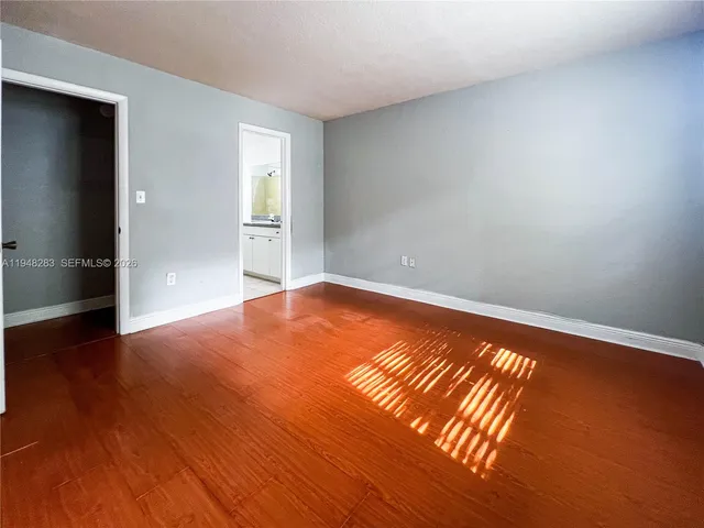 a view of empty room with wooden floor