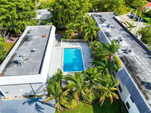 an aerial view of a house with a yard and garden in front of it