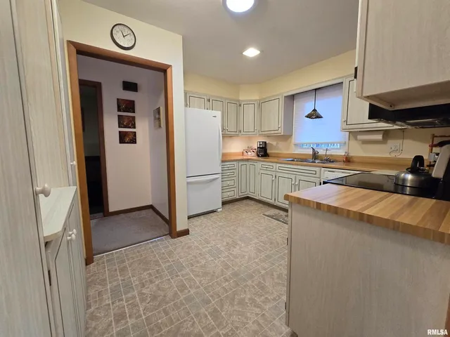 a kitchen with stainless steel appliances granite countertop a stove top oven a sink a dining table and chairs