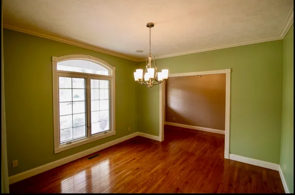 a view of a livingroom with wooden floor and a ceiling fan