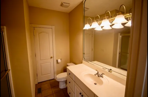 a bathroom with a sink mirror and toilet