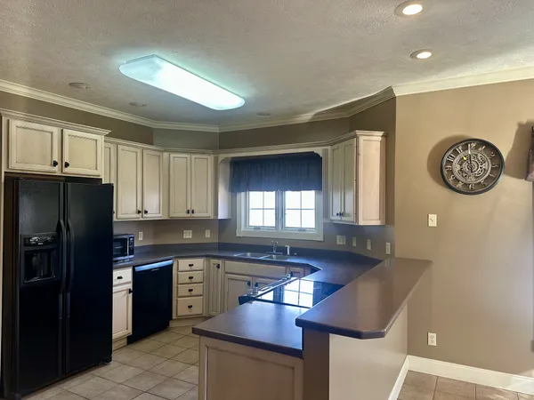 a kitchen with granite countertop stainless steel appliances a refrigerator a sink a stove and cabinets
