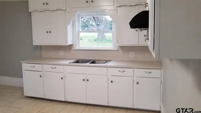a kitchen with stainless steel appliances white cabinets and a sink