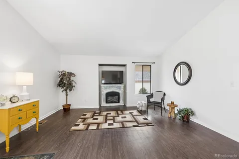 a living room with furniture fireplace and wooden floor