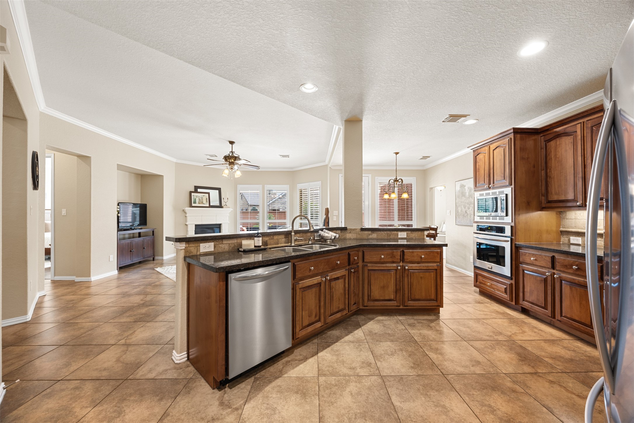 2603 Hendricks Lakes Drive Spring, TX 77388 - Photo 11 of 50 Expansive kitchen anchored by a large granite island with seating, rich wood cabinetry, built-in stainless appliances, and open sightlines to the family room and breakfast area.
