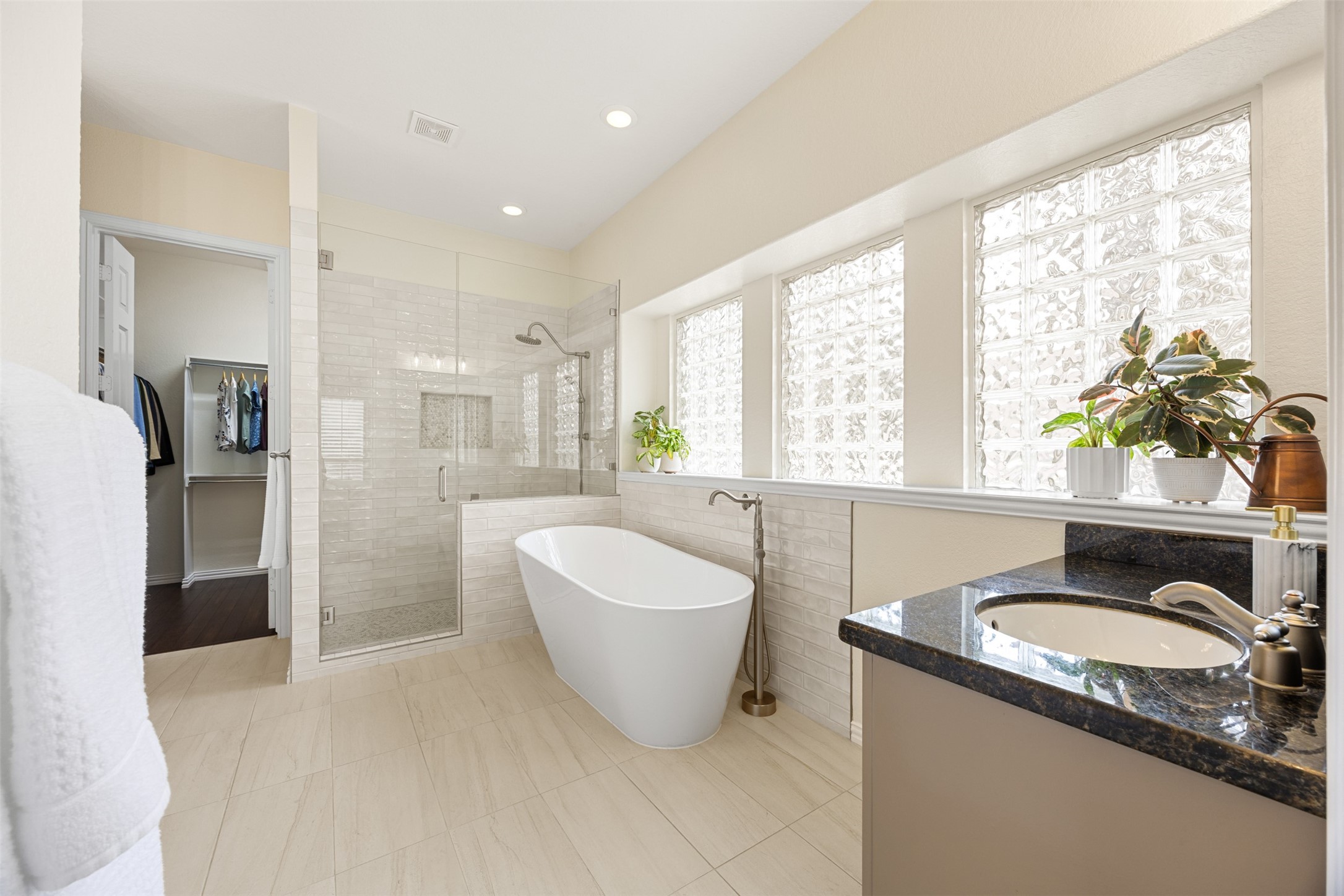 2603 Hendricks Lakes Drive Spring, TX 77388 - Photo 20 of 50 Spa-inspired primary bathroom complete with elegant freestanding tub, oversized walk-in shower with frameless glass enclosure, custom tilework, and bright glass block windows that provide privacy without sacrificing natural light.