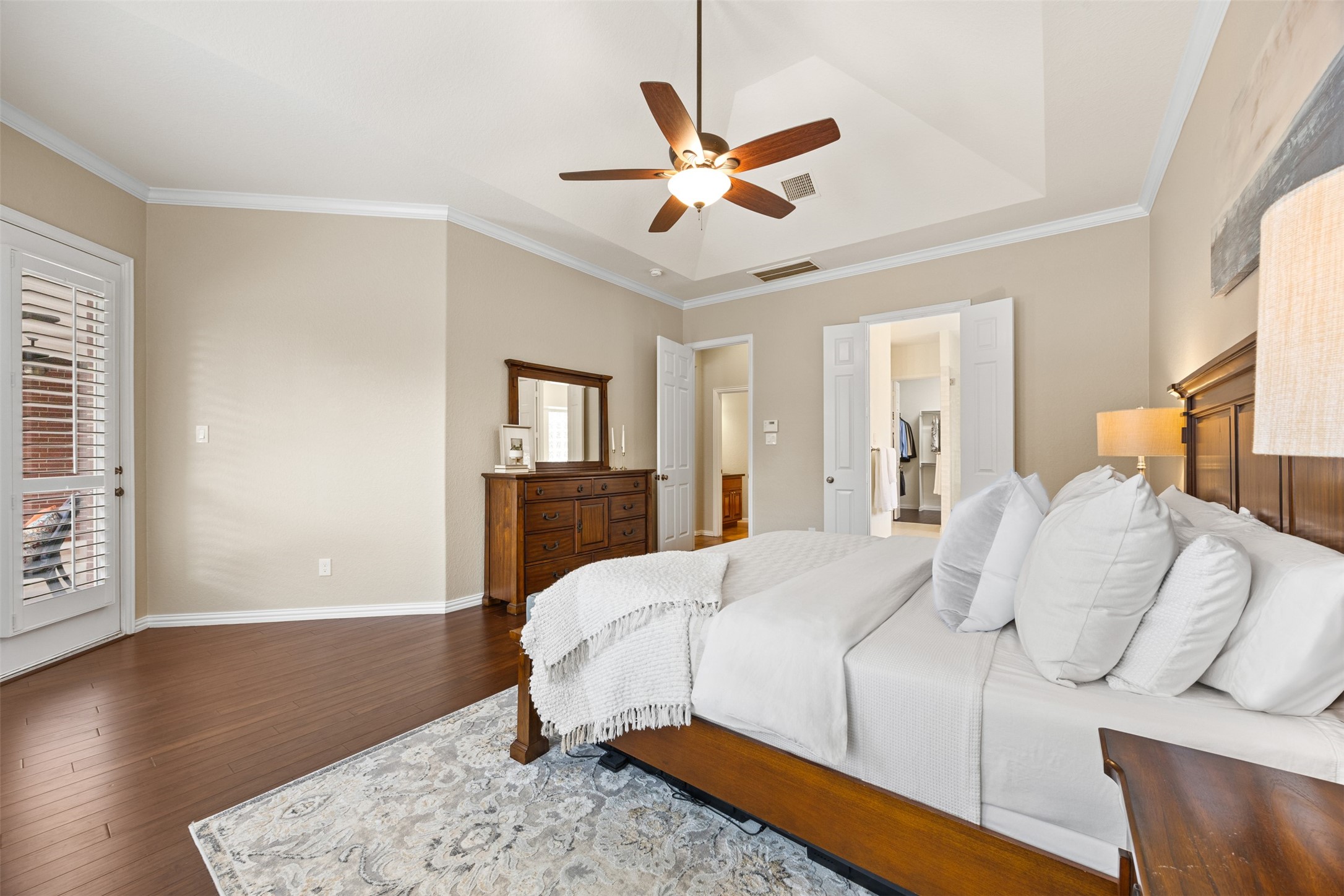 2603 Hendricks Lakes Drive Spring, TX 77388 - Photo 25 of 50 Spacious primary suite featuring tray ceilings, hardwood flooring, and abundant natural light with views of the backyard pool. Generous layout offers room for a sitting area and seamless access to the en-suite bath and walk-in closet.