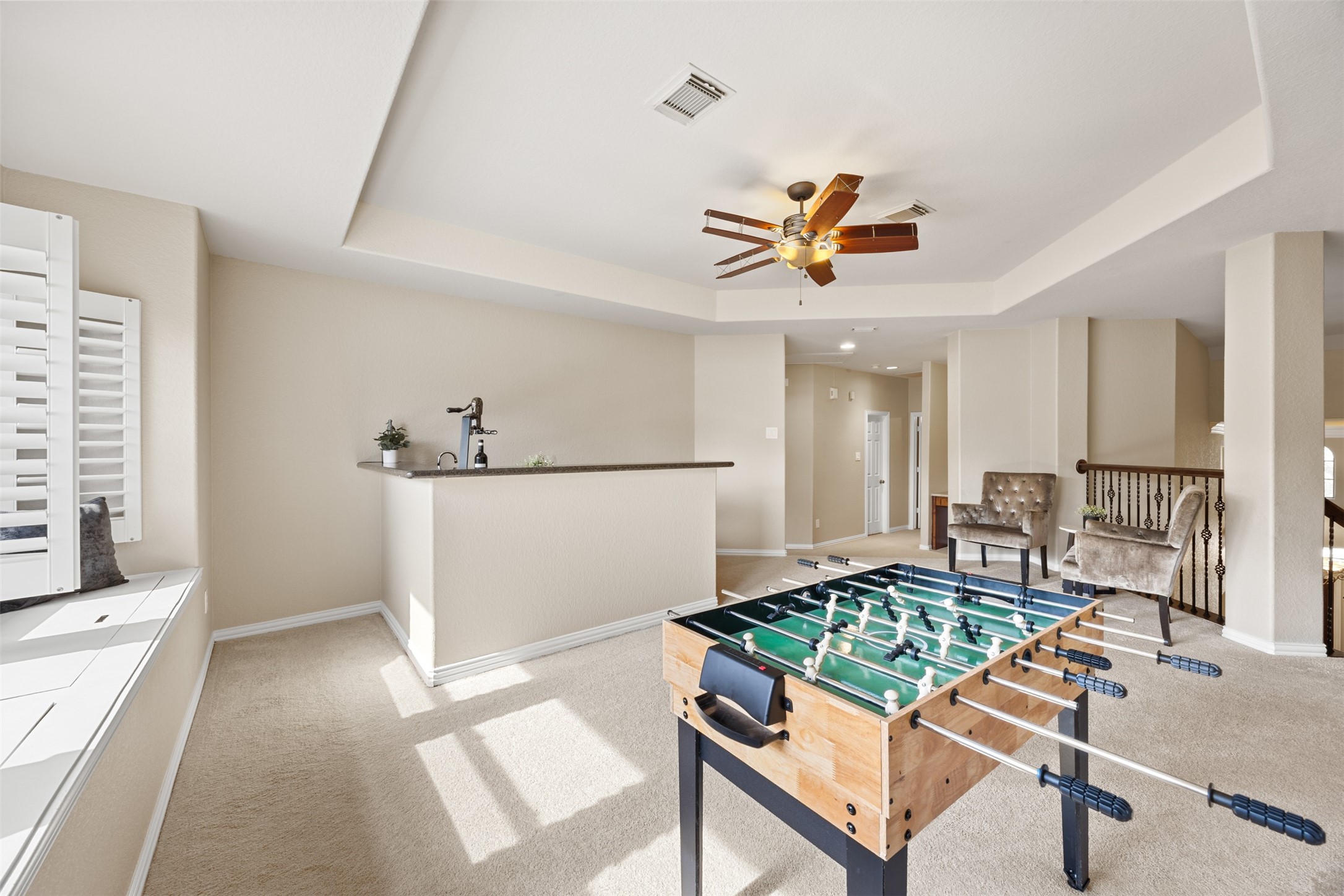 2603 Hendricks Lakes Drive Spring, TX 77388 - Photo 27 of 50 Sun-filled upstairs game room with tray ceiling, wet bar, and charming window seat storage—perfect for game nights, a secondary living area, or flexible family space.