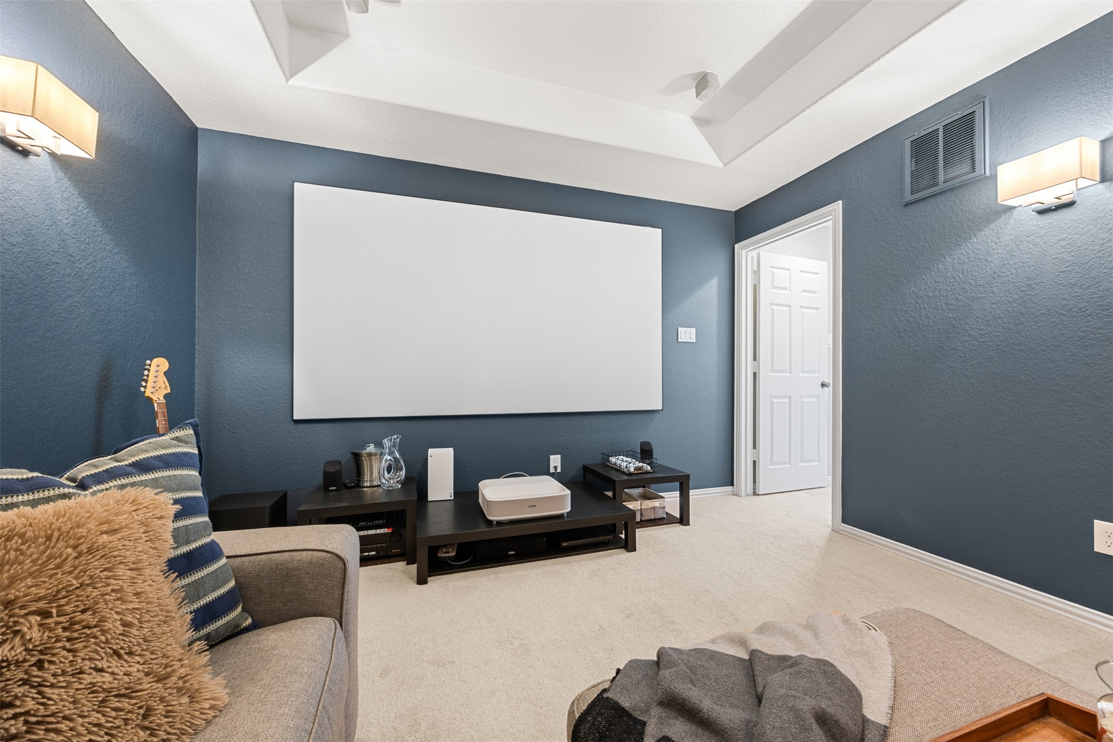 2603 Hendricks Lakes Drive Spring, TX 77388 - Photo 29 of 50 Expansive media room with tray ceiling, wall sconces, and plush carpeting—perfect for movie nights, gaming, or a secondary living space. Generous proportions provide ample room for oversized seating and flexible layout options.