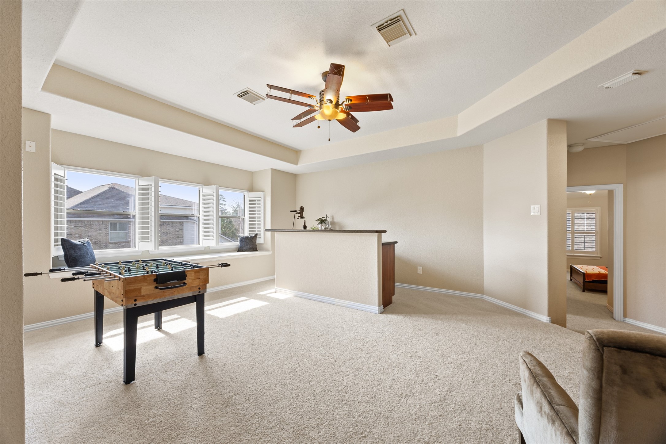 2603 Hendricks Lakes Drive Spring, TX 77388 - Photo 30 of 50 Expansive upstairs game room filled with natural light, featuring a tray ceiling, charming window seat, and convenient wet bar for effortless entertaining.