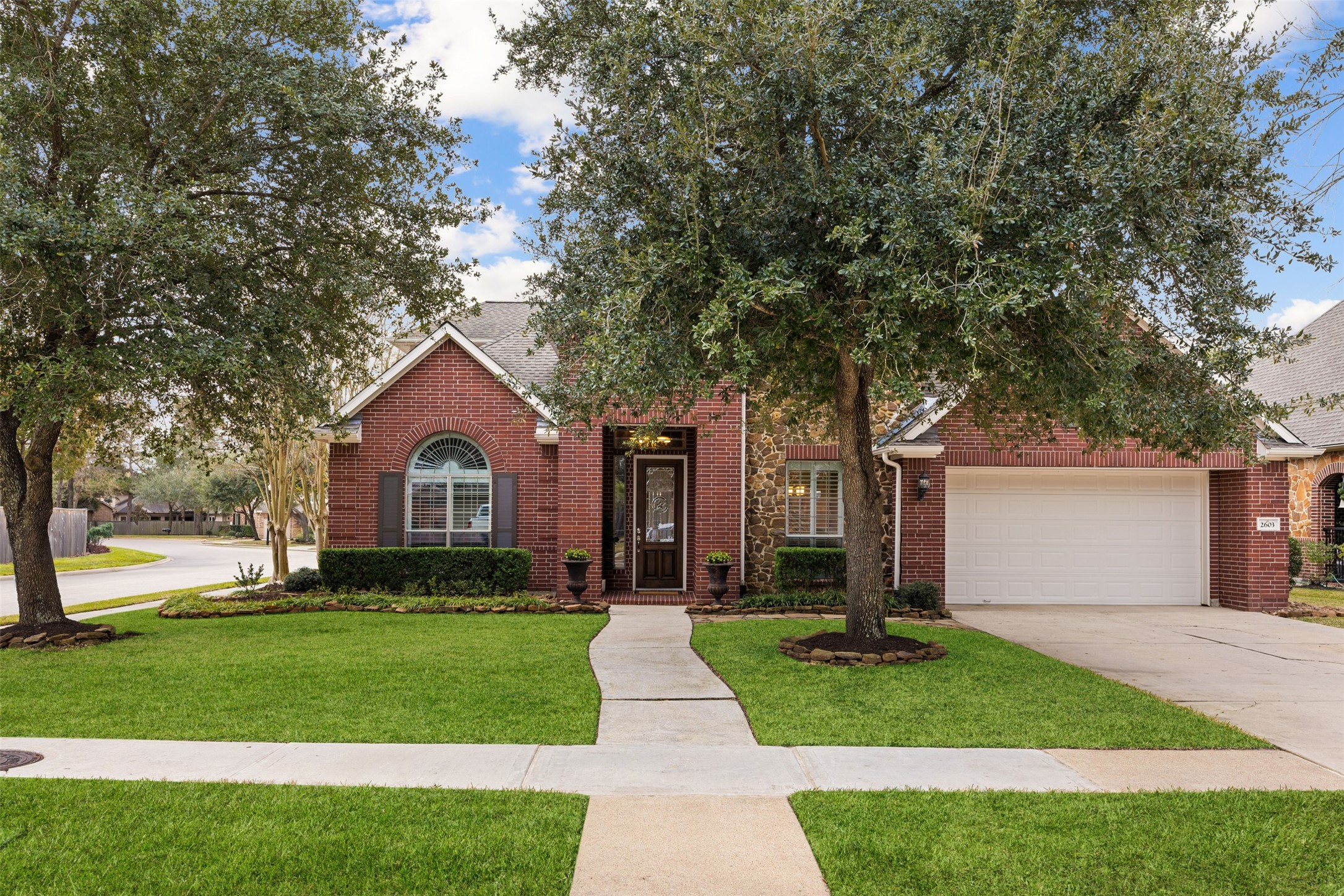 2603 Hendricks Lakes Drive Spring, TX 77388 - Photo 4 of 50 Beautiful brick and stone façade situated on a prominent corner lot with mature trees and manicured landscaping. The inviting front entry and oversized driveway enhance the curb appeal of this spacious 5-bedroom home in highly desirable Klein ISD.
