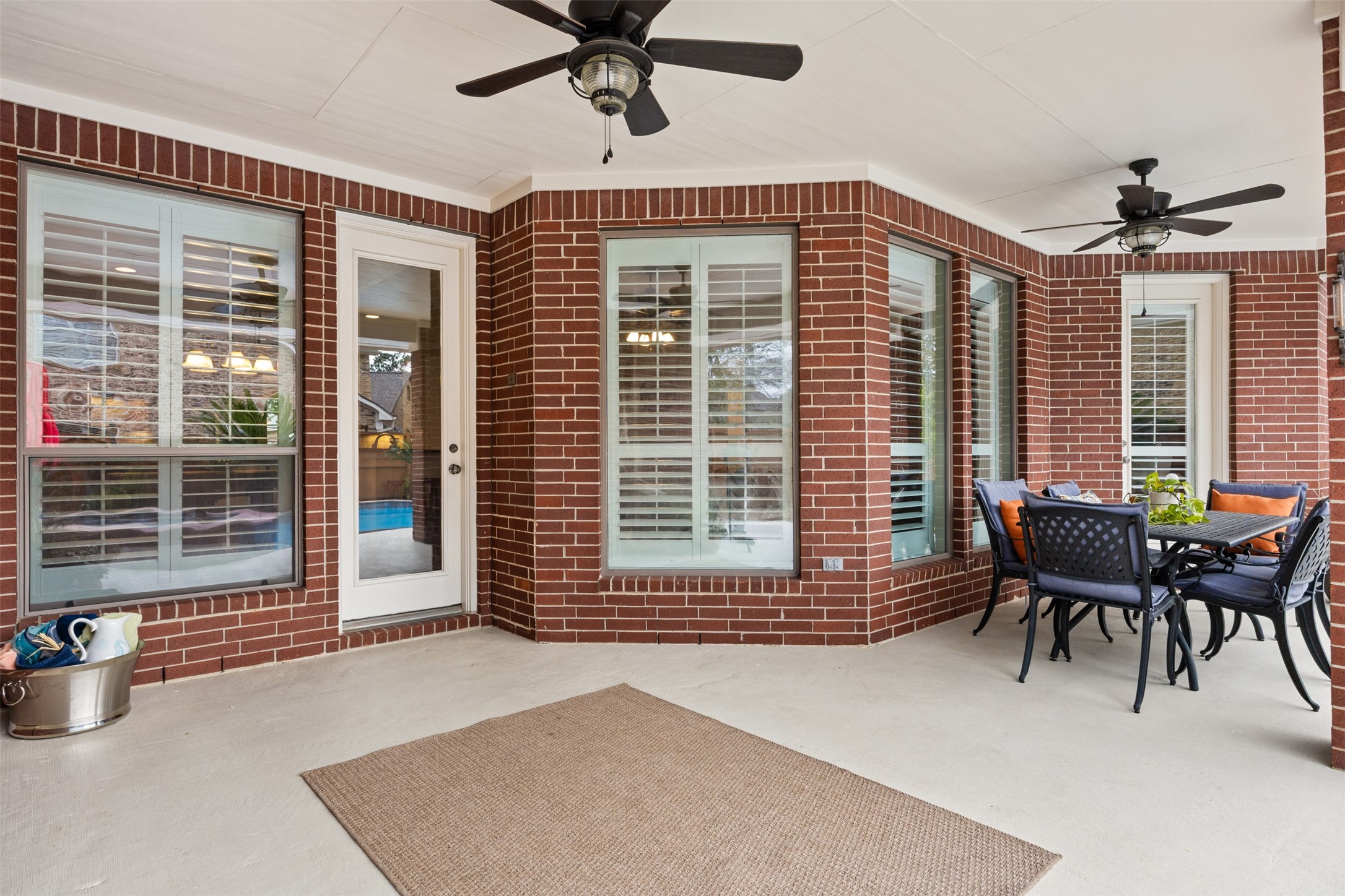 2603 Hendricks Lakes Drive Spring, TX 77388 - Photo 43 of 50 Extended covered patio overlooking the pool, complete with dual ceiling fans and ample seating space—ideal for gatherings or quiet evenings outdoors.