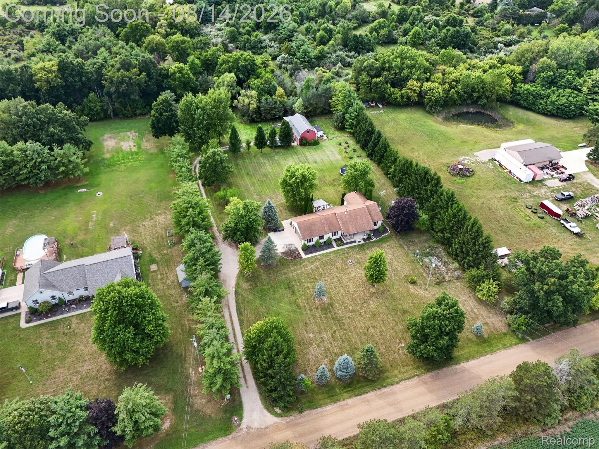 11342 South Morrish Road Gaines, MI 48436 - Photo 23 of 26 Expansive property featuring multiple structures, mature trees, a private pond, and a gravel driveway