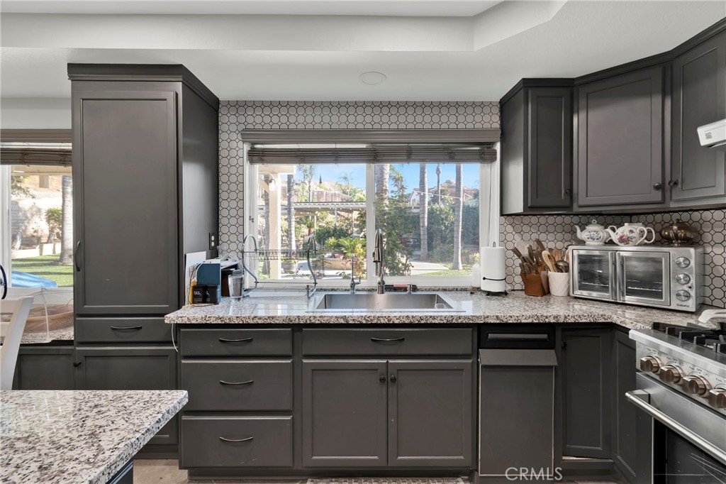 3350 May Court Riverside, CA 92503 - Photo 39 of 55 a kitchen with granite countertop a sink a stove and a wooden cabinets