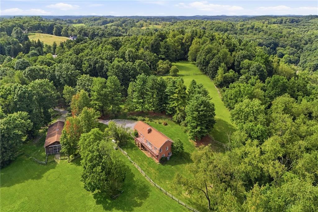 45 Stonedale Road Sewickley, PA 15143 - Photo 5 of 26 An aerial view reveals open pastures framed by dense woodland, with the barn and ranch home nestled in a private clearing with a potential building lot above the home.