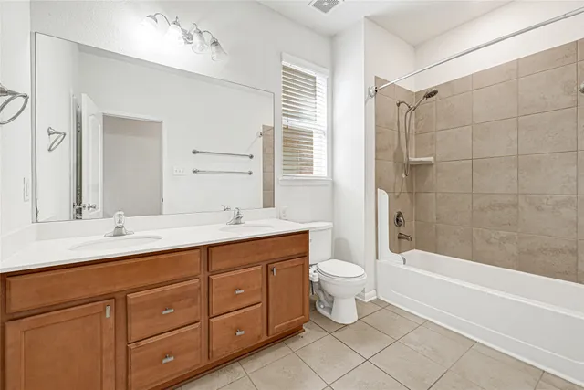 a bathroom with a double vanity sink a toilet and bathtub