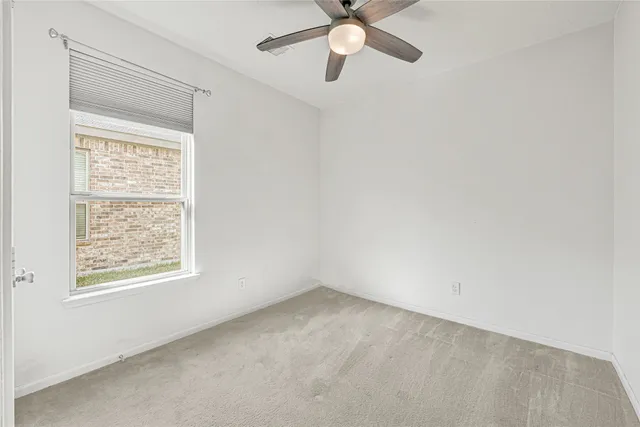 an empty room with a window and a fan