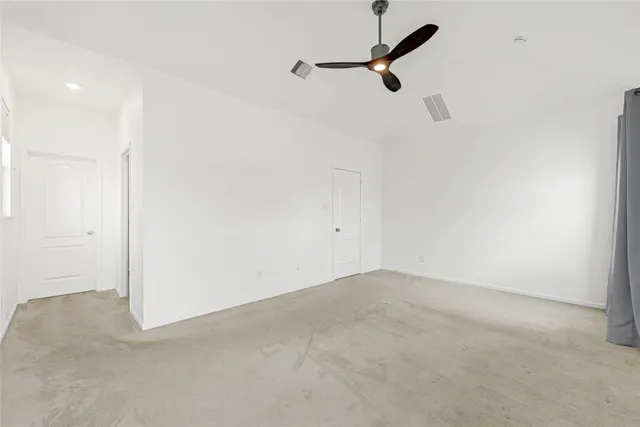 a view of a room with a ceiling fan and wooden floor