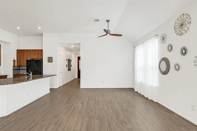 a view of a hallway with wooden floor and a large window