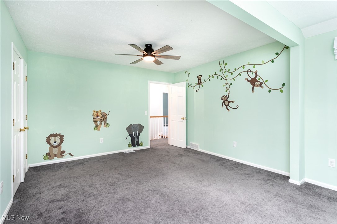 14566 West Ridge Road Novelty, OH 44072 - Photo 36 of 49 Carpeted empty room featuring visible vents, baseboards, and ceiling fan