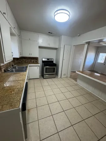 a kitchen with stainless steel appliances granite countertop a stove a sink and a microwave