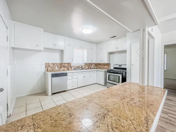a kitchen with stainless steel appliances granite countertop a sink and a stove