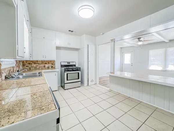 a kitchen with a stove a sink and a refrigerator