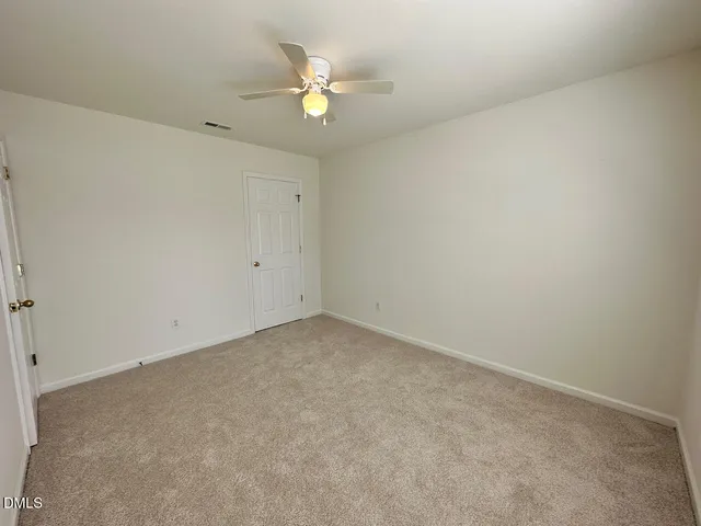 an empty room with a chandelier fan