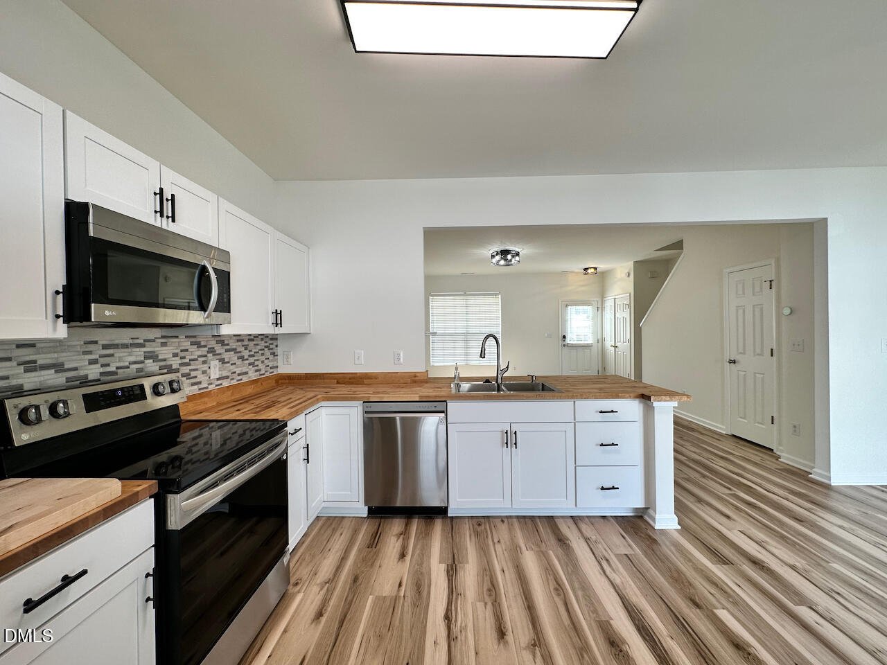 5105 Obion Court Raleigh, NC 27616 - Photo 7 of 22 a large kitchen with granite countertop a stove top oven a sink dishwasher and wooden floor