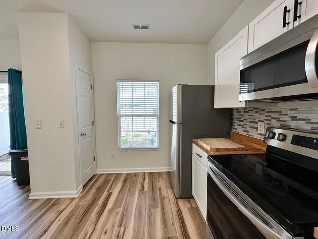 a kitchen with granite countertop a stove and a microwave
