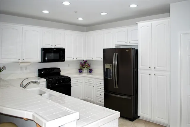 a kitchen with a refrigerator and a stove top oven