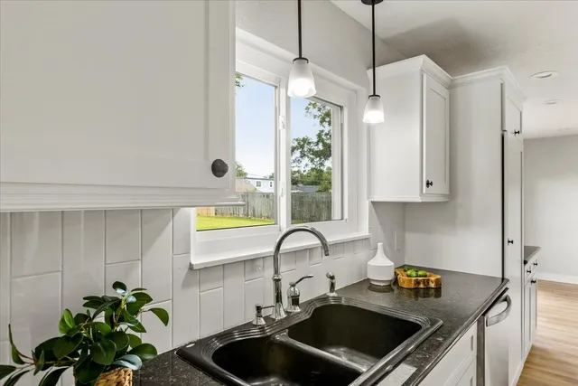 a kitchen with stainless steel appliances granite countertop a stove a sink dishwasher and a refrigerator with wooden floor