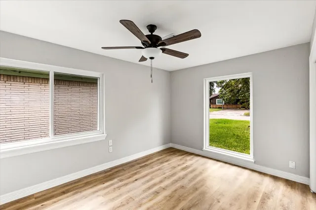 a view of empty room with wooden floor