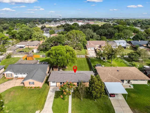 an aerial view of a house with a yard and lake view
