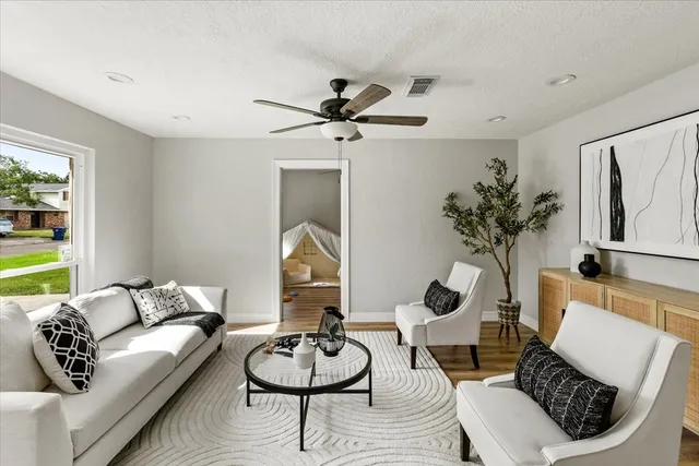 a living room with furniture and a wooden floor
