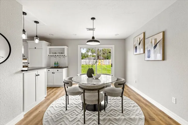 a dining room with furniture a chandelier and wooden floor