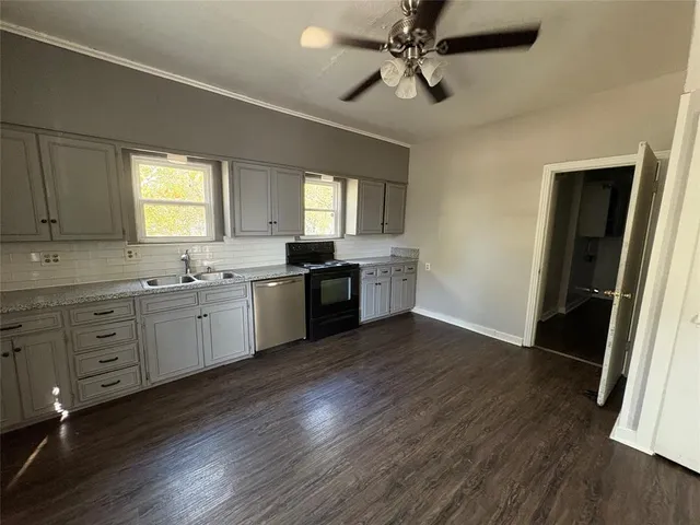 a kitchen with stainless steel appliances sink cabinets and wooden floor