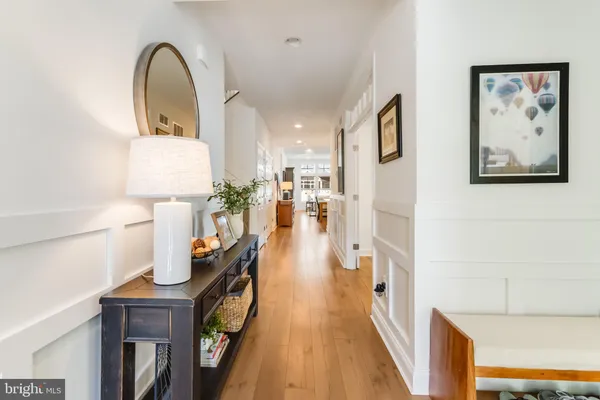 a kitchen with stainless steel appliances kitchen island granite countertop a refrigerator a stove and white cabinets with wooden floor